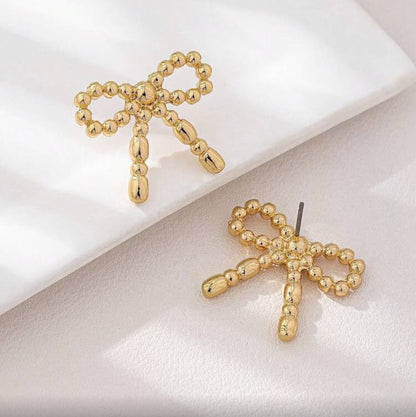 Gold Beaded Bow Earrings on a light background