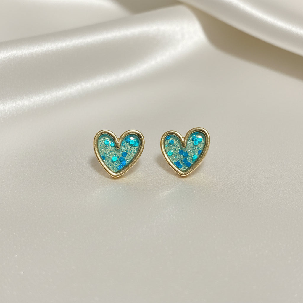 Turquoise Glitter Heart Earrings with glittery blue and gold finish on a white background