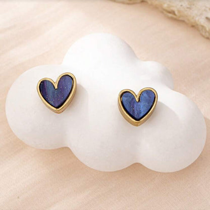 Blue Gold Dust Heart Earrings on a white cloud-shaped stand.