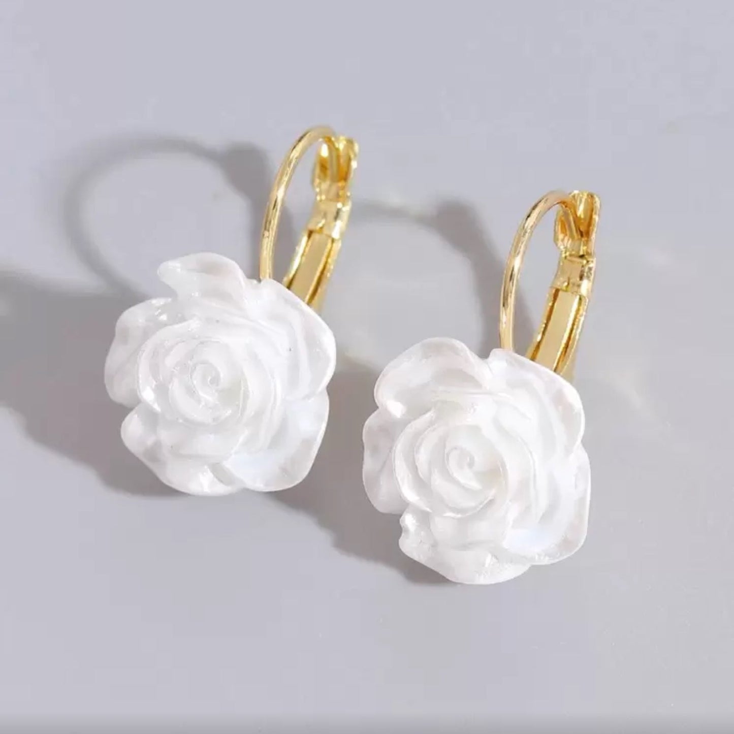 White Rose Earrings with gold hooks on a light gray background