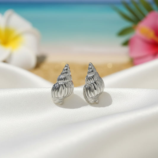 Silver Seashell Earrings on white fabric, tropical setting