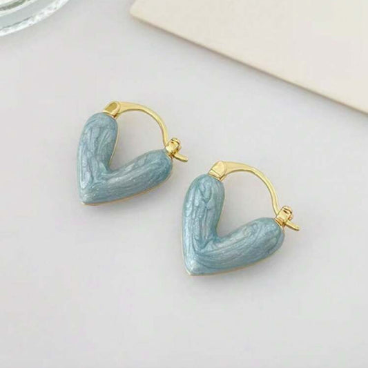 Blue Stone Heart Earrings with gold accents on a light surface