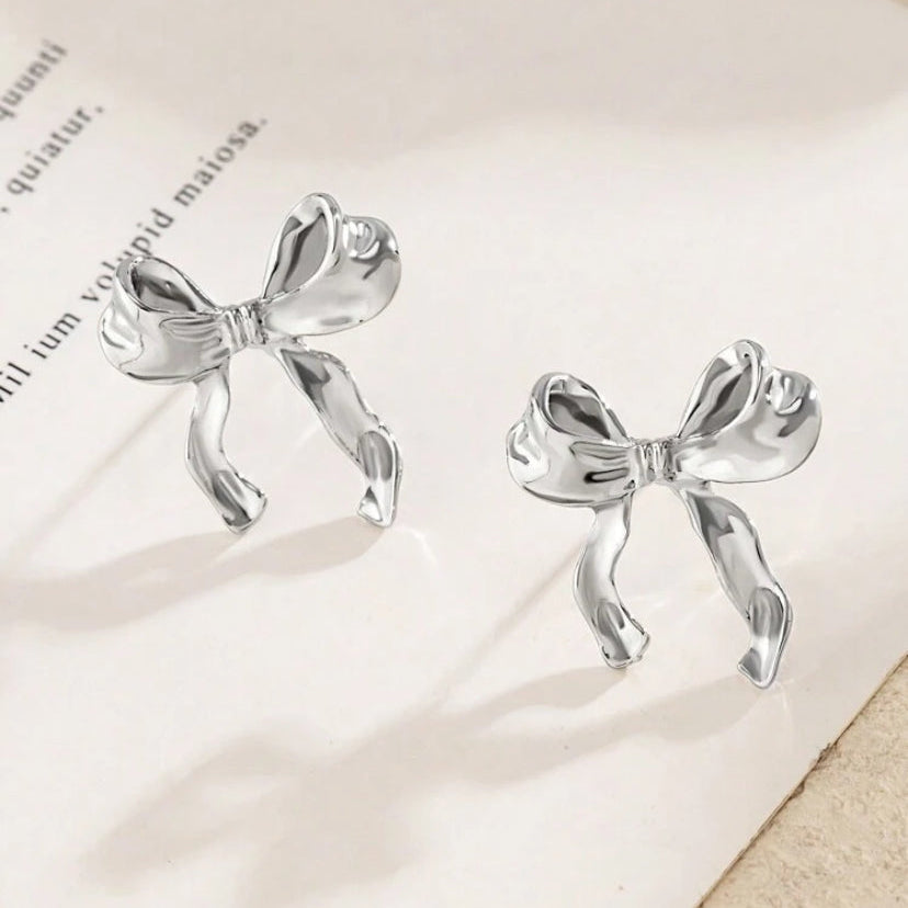 Silver Bow Ribbon Earrings on paper
