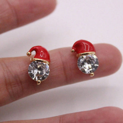 Starlit Santa Earrings held between fingers on a white background