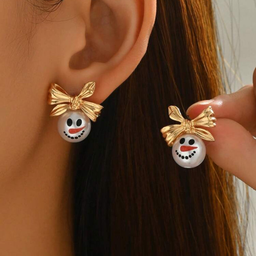 Woman holding and wearing Golden Bow Snowman Earrings