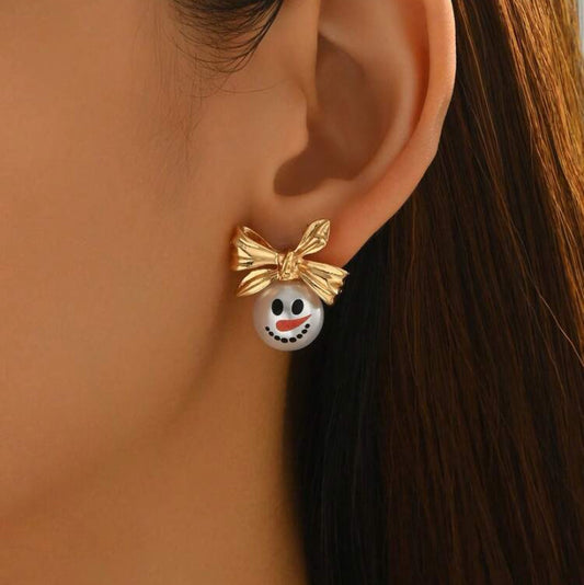 Golden Bow Snowman Earrings worn by a woman