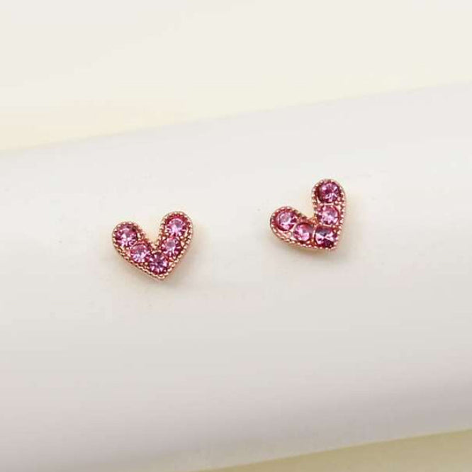 Petite Pink Zircon Heart Earrings on a white cushion with a light background