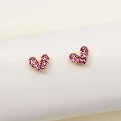 Petite Pink Zircon Heart Earrings on a white cushion with a light background