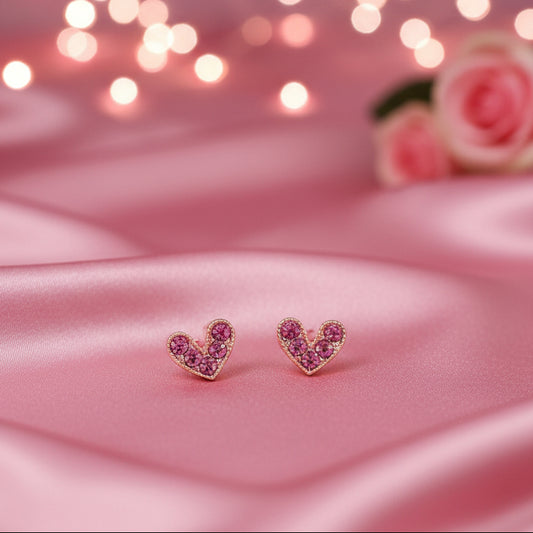 Petite Pink Zircon Heart Earrings on a white cushion with a light background