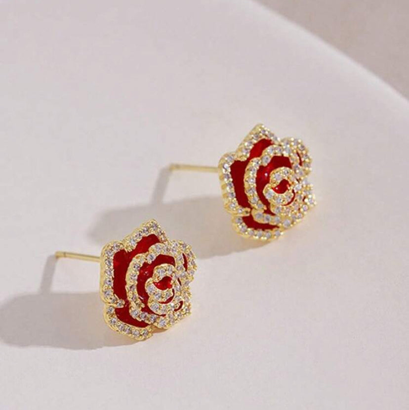 Rhinestone Rose Earrings with red centers and gold accents on a white surface
