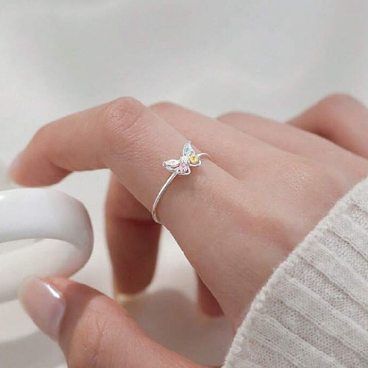Pastel Butterfly Adjustable Ring on a finger against a neutral background