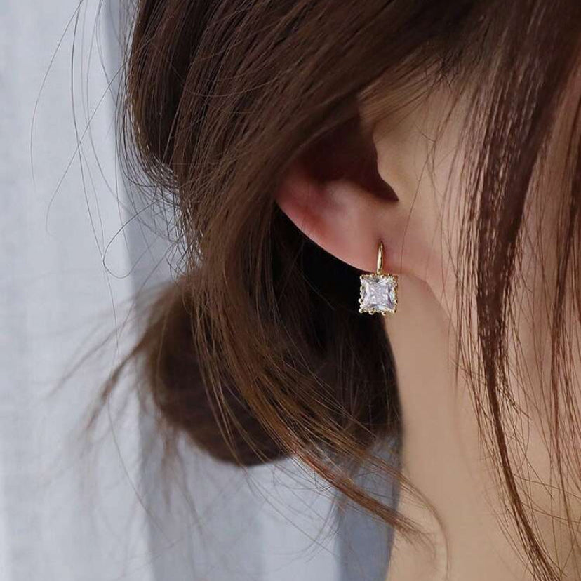 Close-up of a woman wearing a Classic Square Zircon Drop Earring with a blurred background