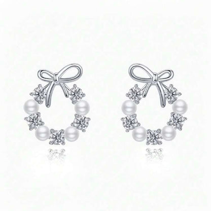 Pair of Silver Bow Wreath Earrings with bow and pearl design on a white background