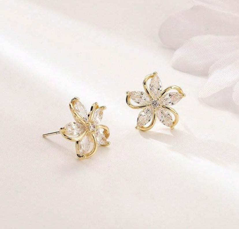Gold Crystal Flower Earrings with clear gemstones on a light background