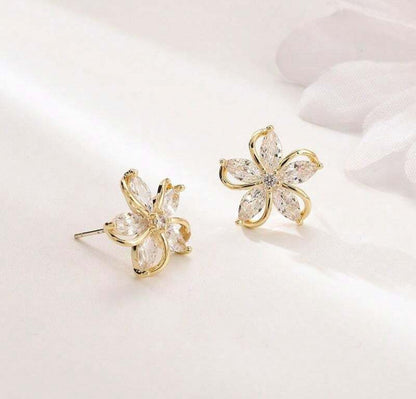 Gold Crystal Flower Earrings with clear gemstones on a light background