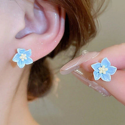Close-up of a person wearing Blue Petal Blossom Earrings.