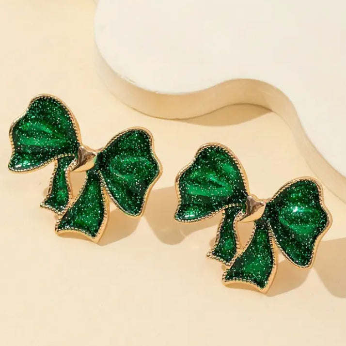 Emerald Glitter Bow Earrings on a beige background