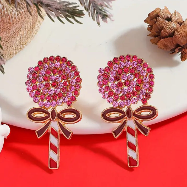 Oversized Holiday Candy Swirl Earrings with pink gemstones on a red background.