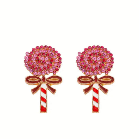 Oversized Holiday Candy Swirl Lollipop-shaped earrings with pink gemstones and red and white striped sticks on a white background