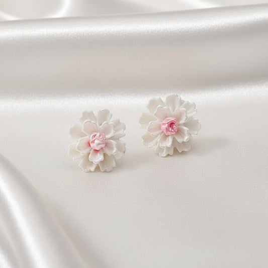 White flower earrings on a satin surface