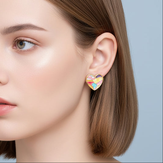 Close-up of a woman wearing Mosaic Pastel Heart Earrings against a light blue background
