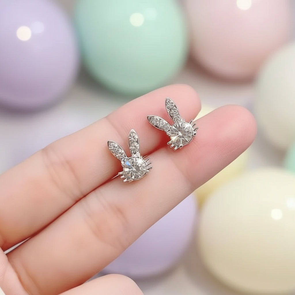 Sweet Bunny Sparkle Earrings held between fingers with colorful blurred background