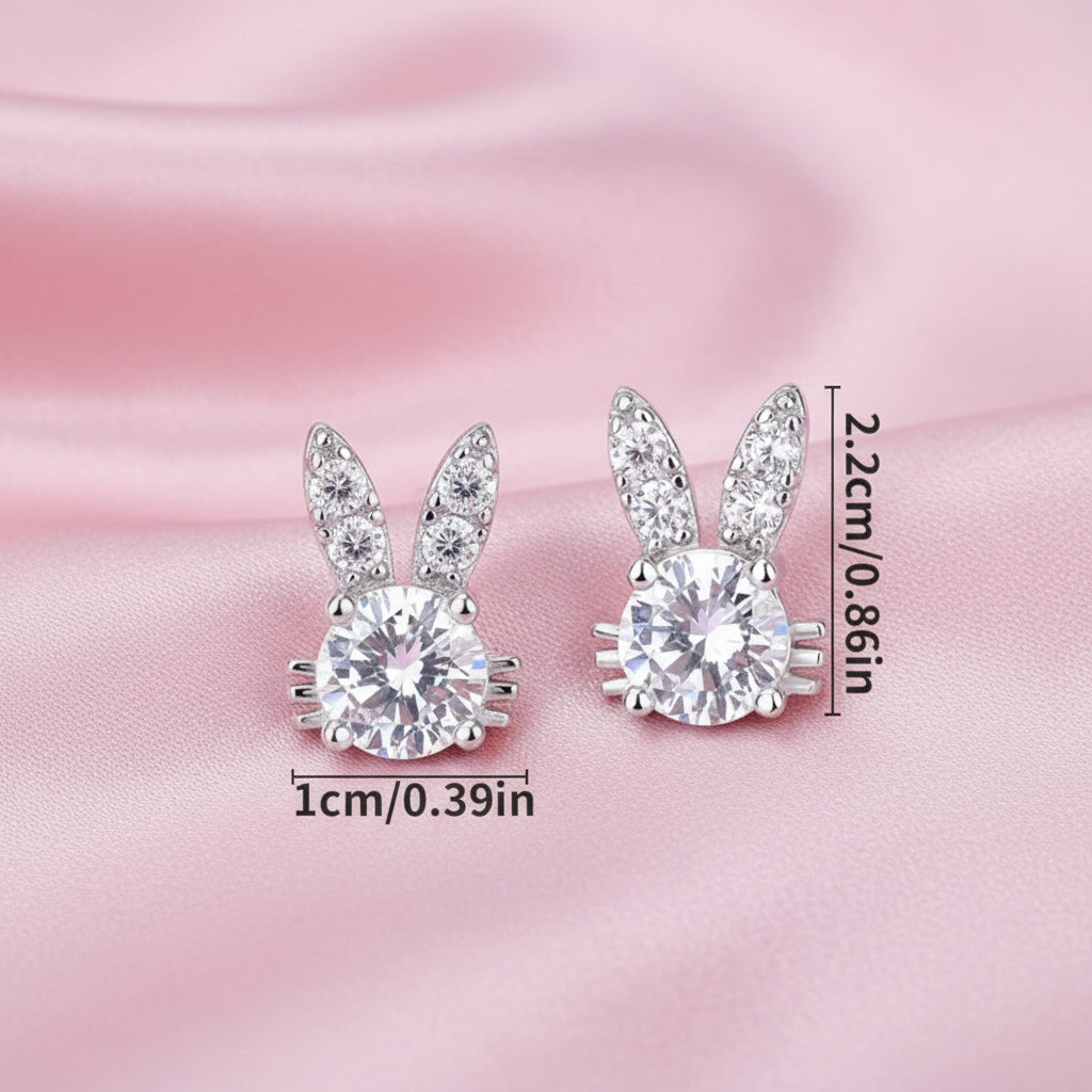 Sweet Bunny Sparkle Earrings with clear gemstones on a pink satin background.