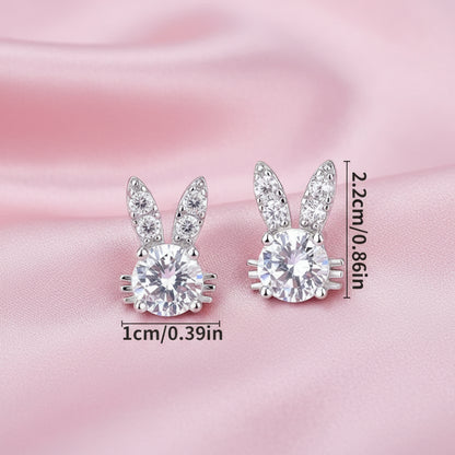 Sweet Bunny Sparkle Earrings with clear gemstones on a pink satin background.