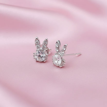 Sweet Bunny Sparkle Earrings with clear gemstones on a pink satin background