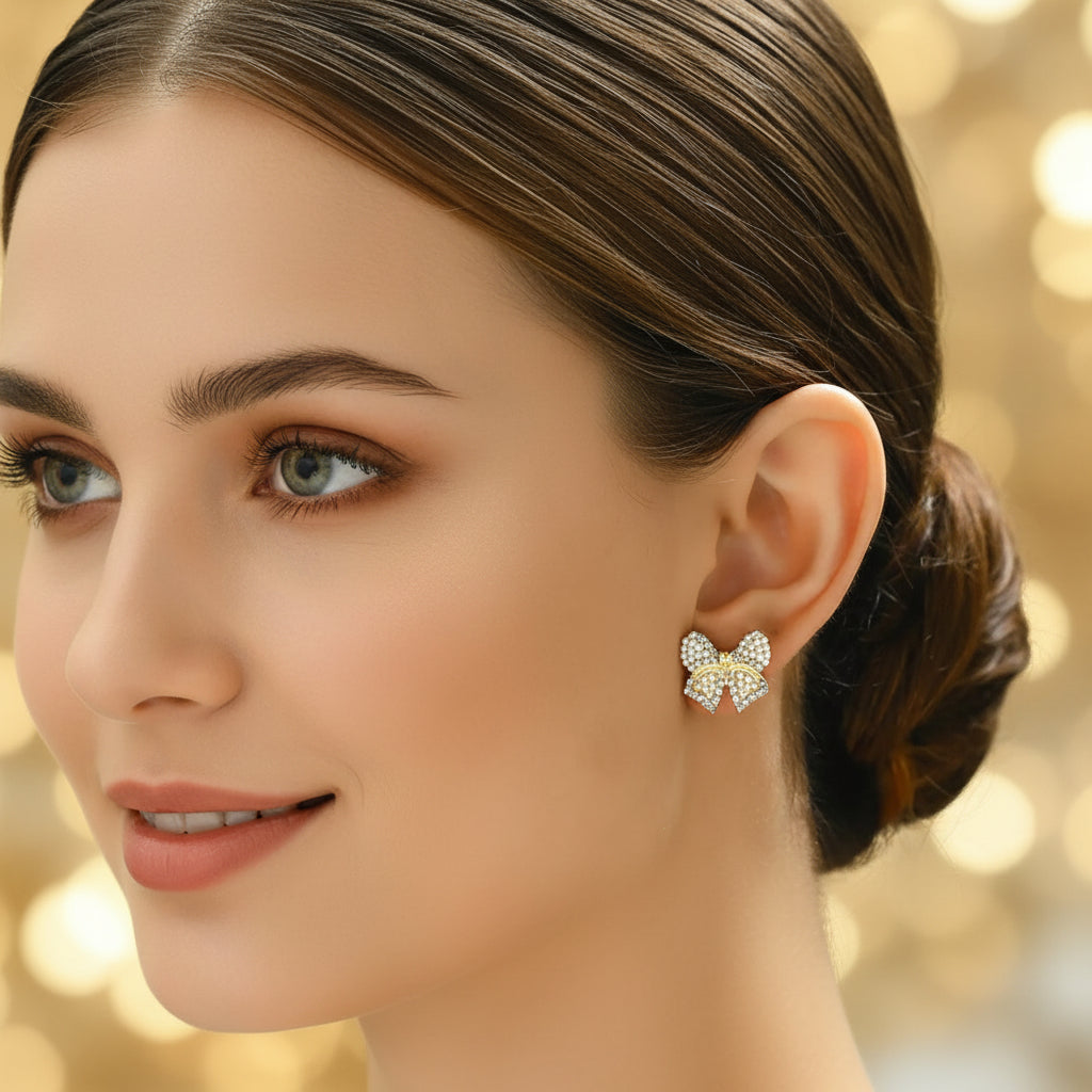 Classic Pearl Bow & CZ Earrings with pearl details worn by a person.