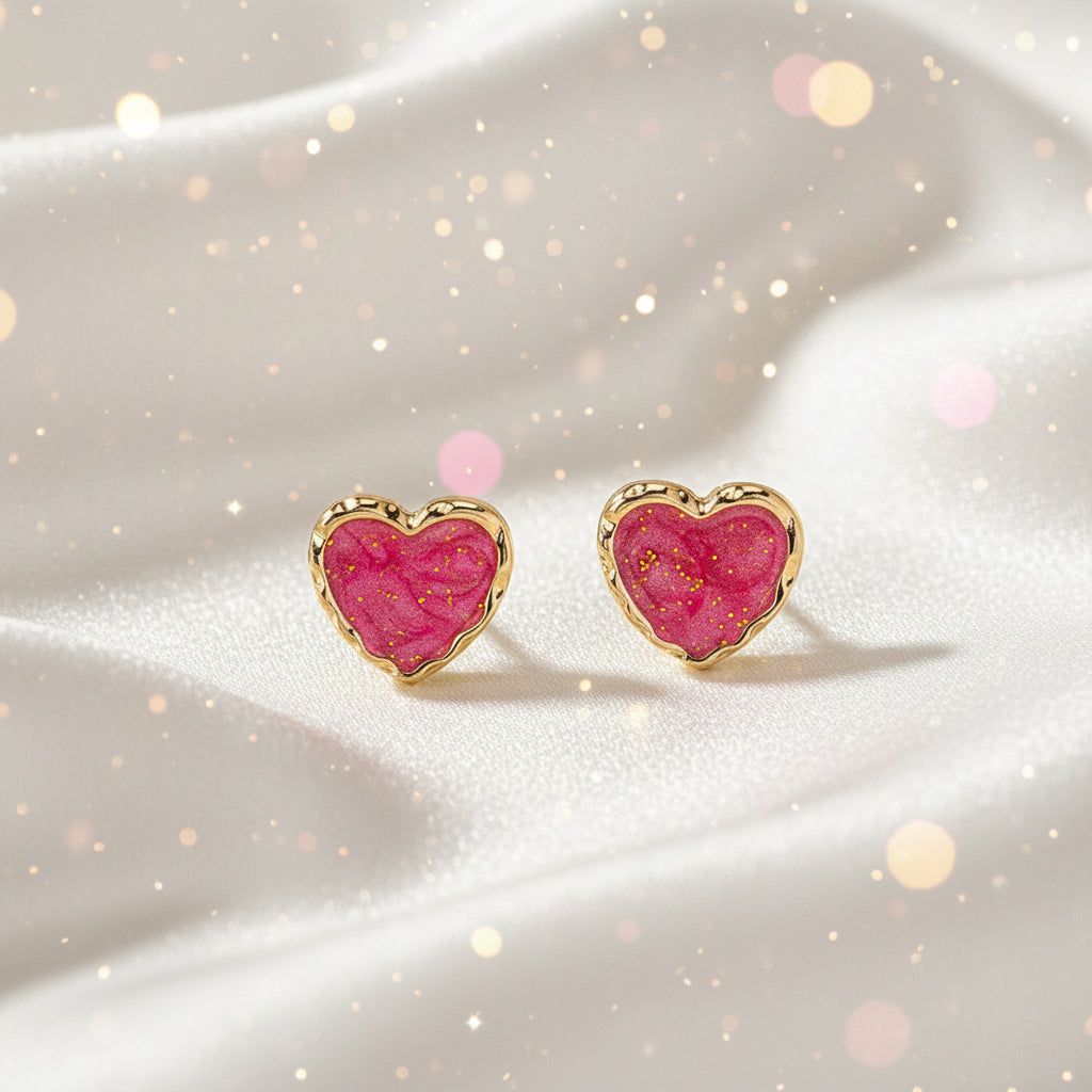 Pink Gold Dust Heart Earrings with pink center and gold border on beige background