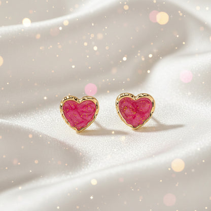 Pink Gold Dust Heart Earrings with pink center and gold border on beige background