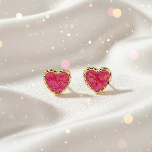 Pink Gold Dust Heart Earrings with pink center and gold border on beige background