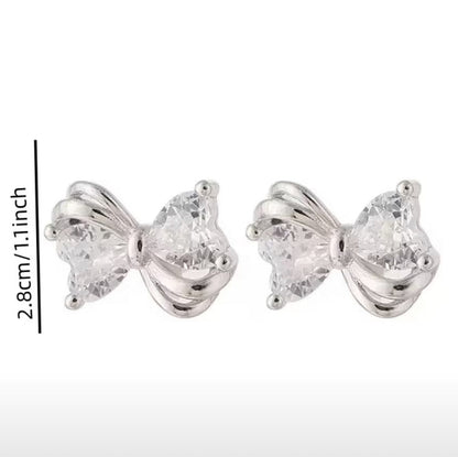 Mini Silver Heart Crystal Bow Earrings with clear gemstones on a white background
