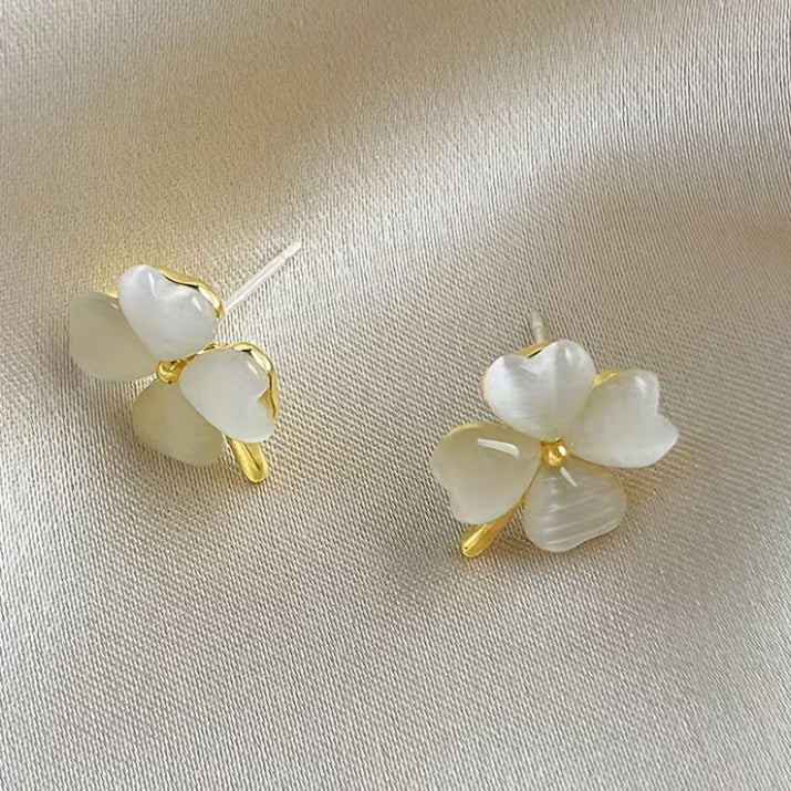 Opalescent Clover Earrings on a satin surface