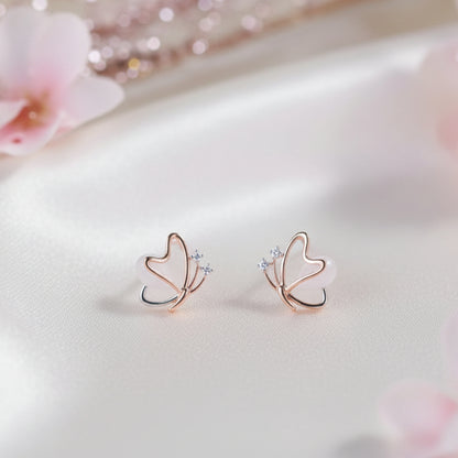Rose Gold Butterfly Pearl Earrings on light fabric