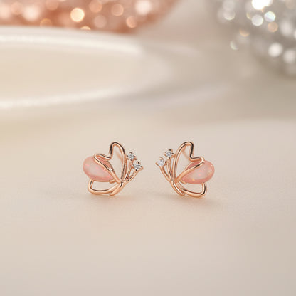 Rose Gold Butterfly Pearl Earrings with pink stones on a soft beige background