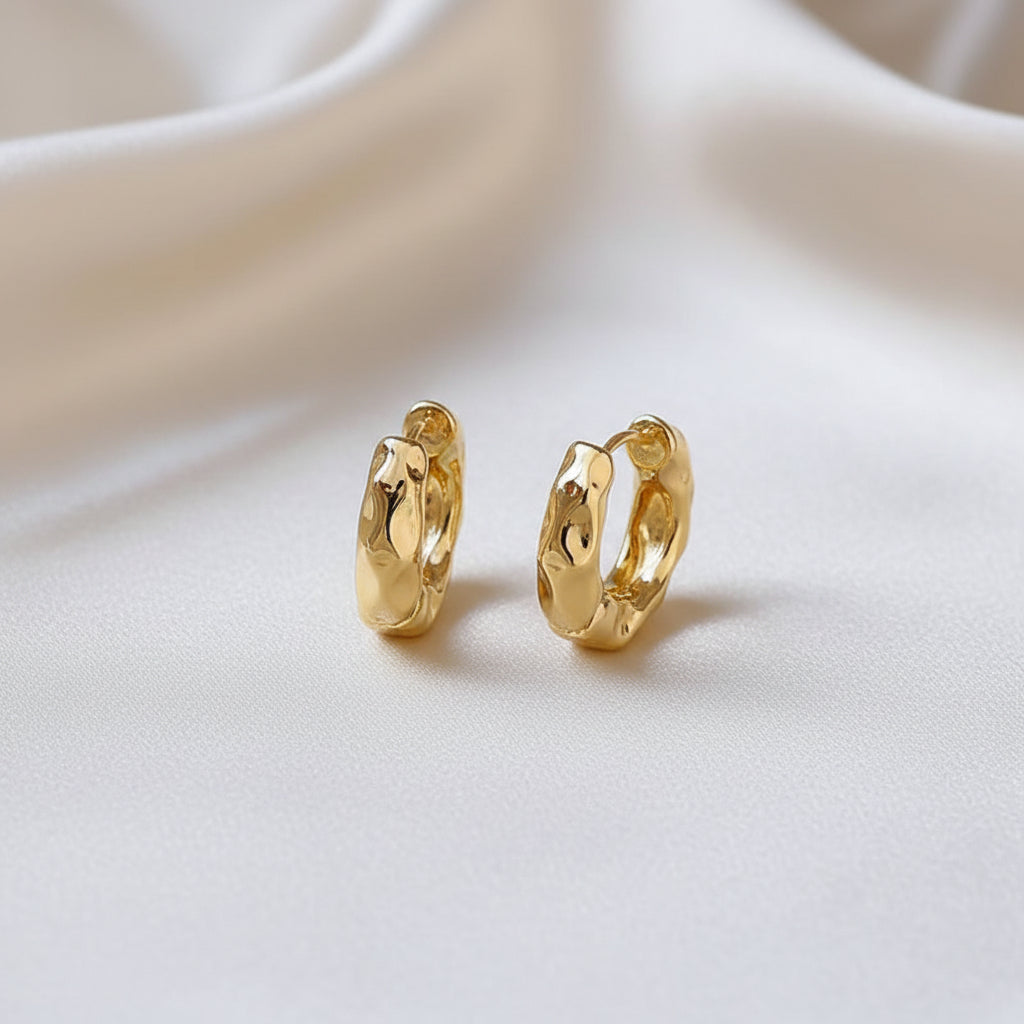 Textured Gold Hoop Earrings on a beige fabric background