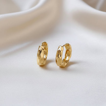 Textured Gold Hoop Earrings on a beige fabric background