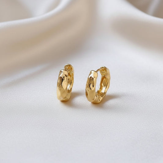 Textured Gold Hoop Earrings on a beige fabric background