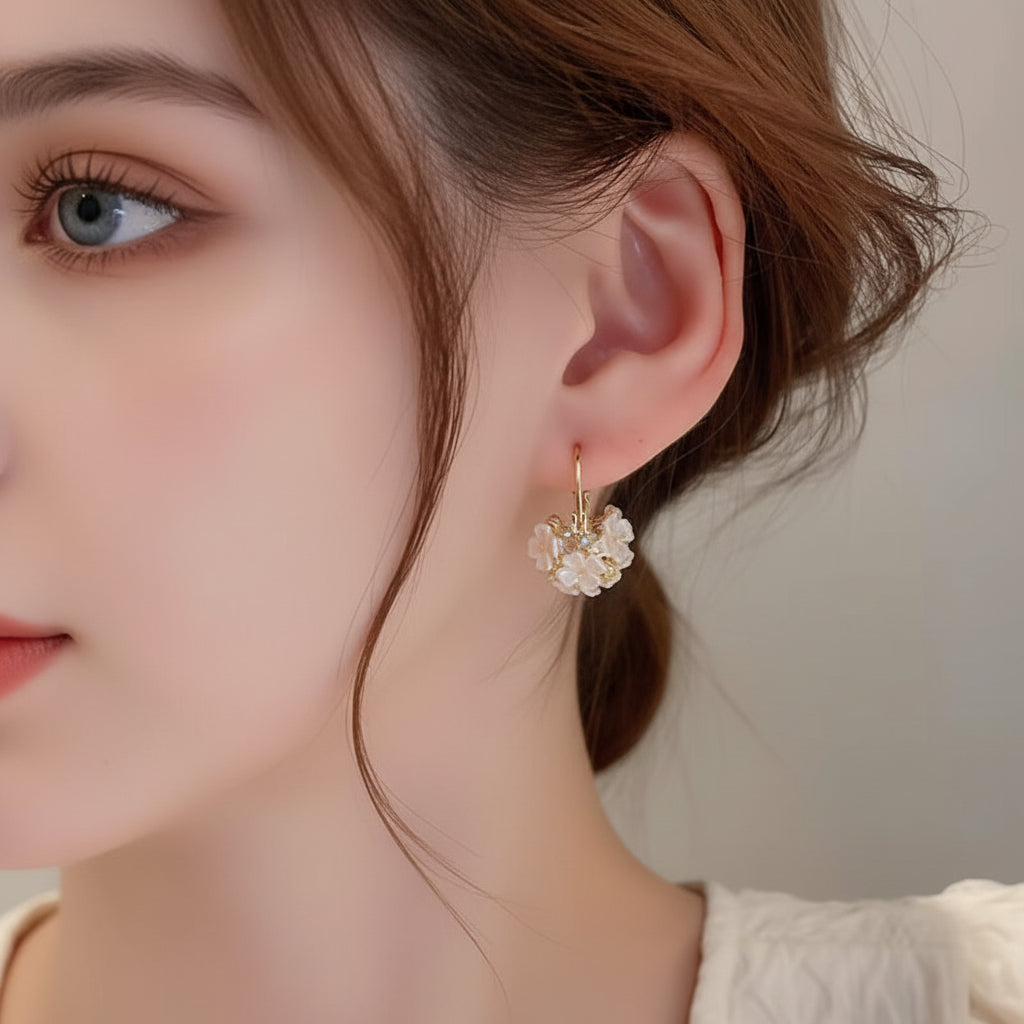 Close-up of a person wearing Gold Pearl Blossom Hoop Earrings with a neutral background