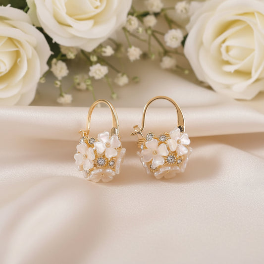 Gold Pearl Blossom Hoop Earrings on a beige background