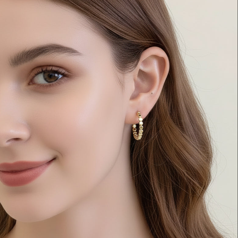 Person wearing a Gold Bead Accent Hoop Earring with a neutral background