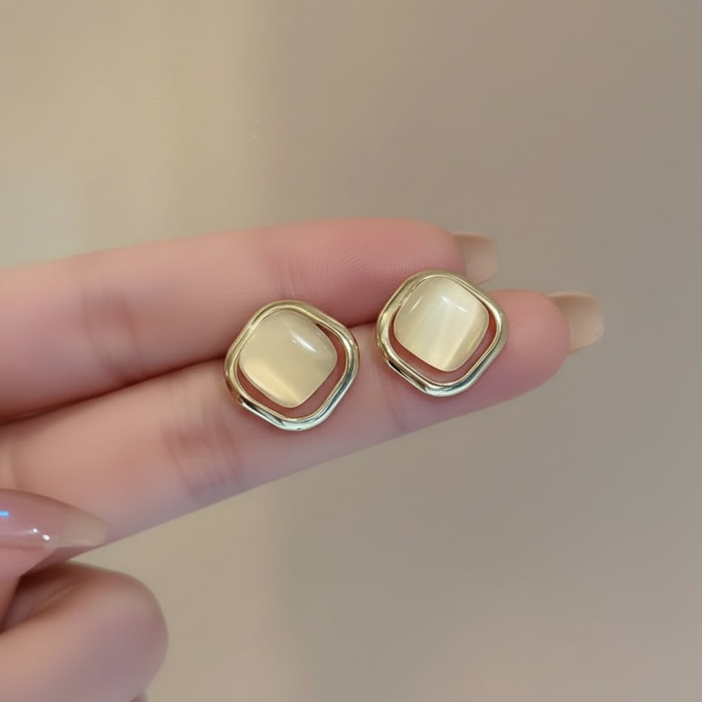 Pearl Square Stud Earrings held between fingers against a neutral background
