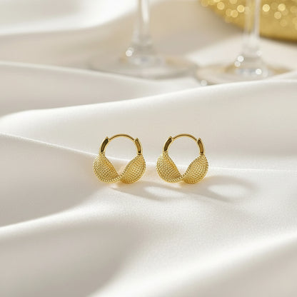 Gold Woven Twist Hoop Earrings on a light fabric