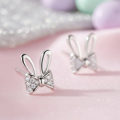 Silver Sparkle Bunny Bow Earrings on pink fabric