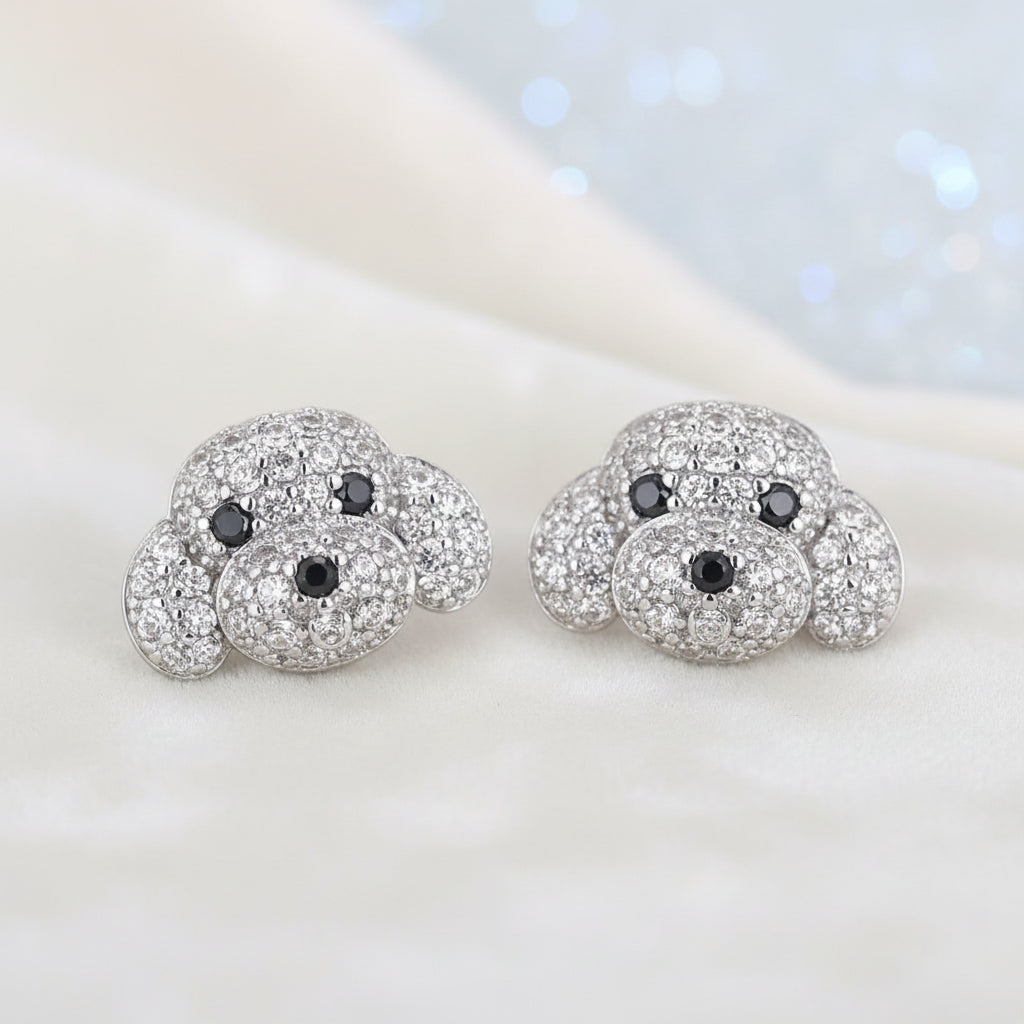 Pavé Puppy Earrings with black and clear gemstones on a light background