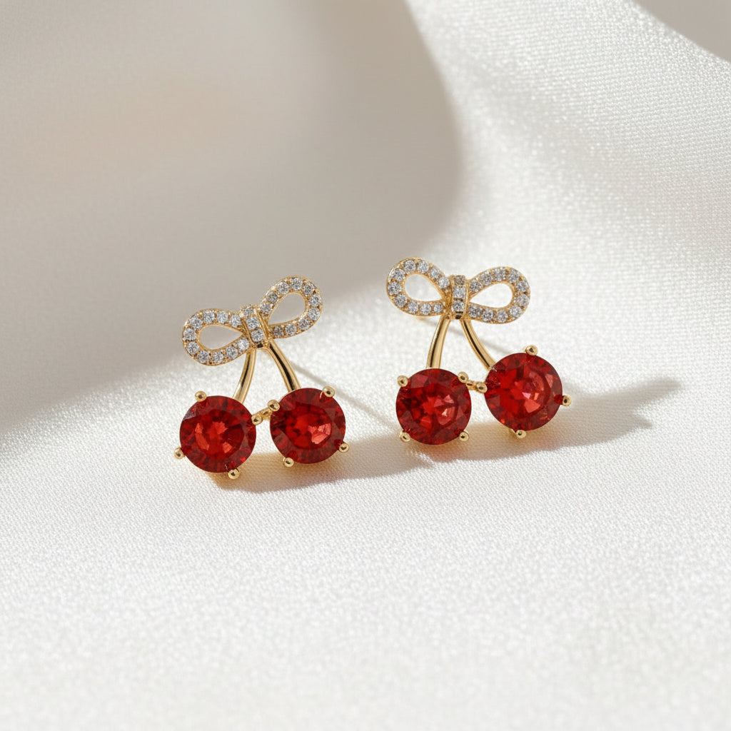 Cherry bow pavé earrings with sparkling red gemstone detail and delicate feminine bow design on a soft elegant background