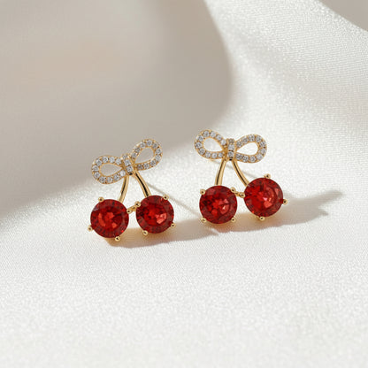 Cherry bow pavé earrings with sparkling red gemstone detail and delicate feminine bow design on a soft elegant background