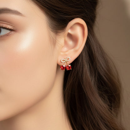 Woman wearing Cherry bow pavé earrings with sparkling red gemstone detail and delicate feminine bow design